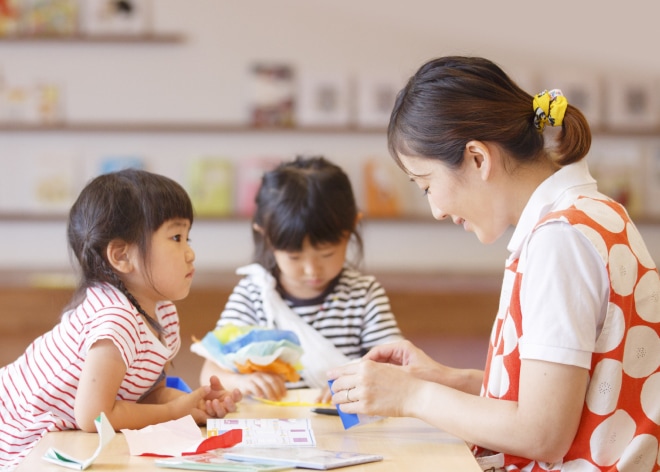笑顔の職員が子どもたちと遊んでいる様子
